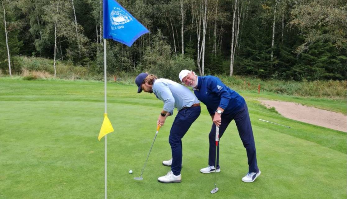Två spelare som läser en putt på greenen